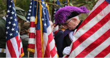 A Knight of Columbus holding a flag in a parade.