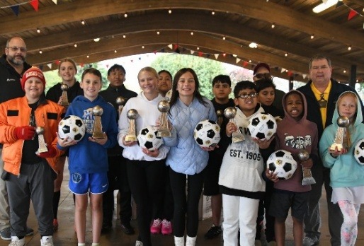 Winners of the 2025 Knights of Columbus Soccer Challenge holding soccer balls and trophies